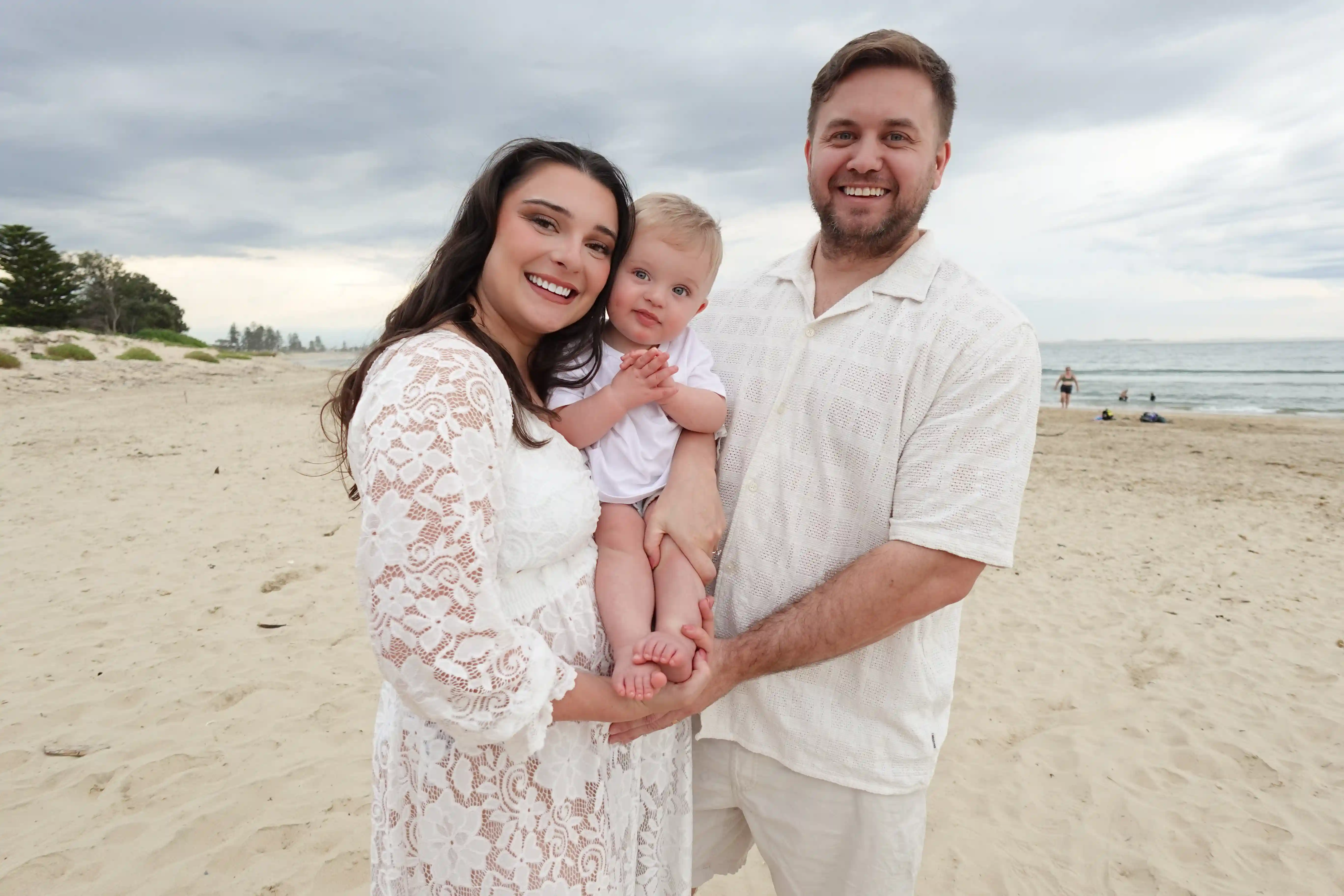 The Elphick family at the beach — business owners with their son, smiling in the sand